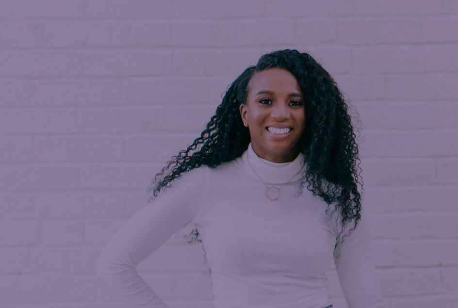 Tkeyah smiling with a white wall background