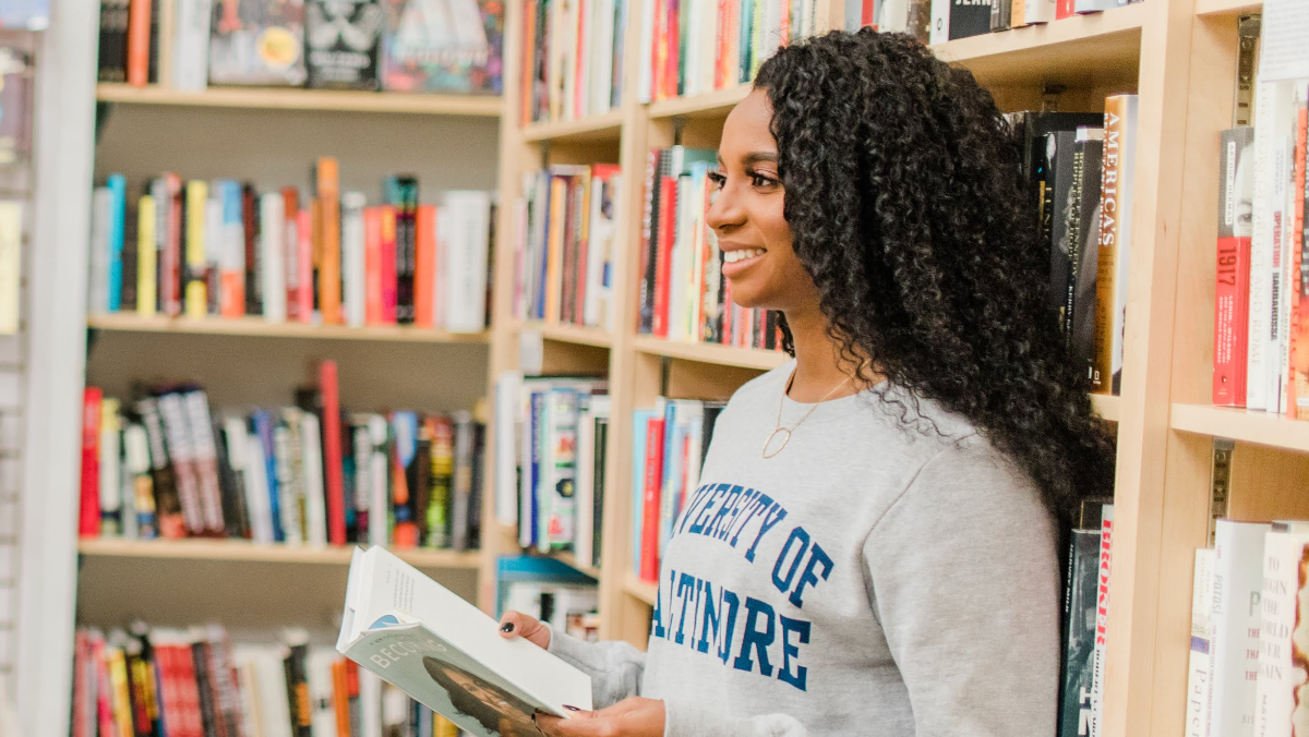 Tkeyah in a library holding a book